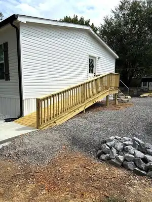White house with new wooden accessibility ramp and railing in rural Kentucky