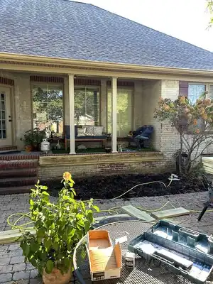 Front porch renovation on a brick home in Murray KY with white columns and construction materials on the yard