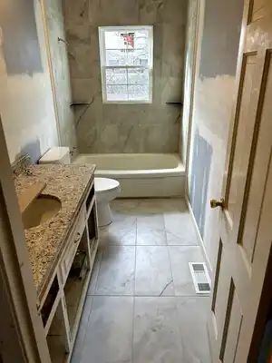 Bathroom under renovation with granite vanity, toilet, and tub/shower in progress