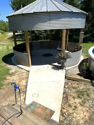 Completed circular metal pavilion with corrugated siding and pool nearby in Kentucky yard