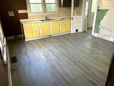 Kitchen renovation in progress with yellow cabinets and grey flooring in a Kentucky home