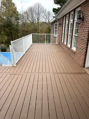Completed brown composite deck with white railing attached to a brick house in Murray KY