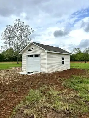 Beige detached shop with white trim and gray roof in rural Murray, KY