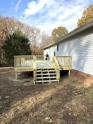 New wooden deck attached to a house in Murray KY with stairs and railing